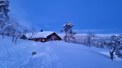 a house covered in snow in front at Heimstølen - Cabin at Sørbølfjell in Flå