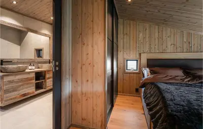 a bedroom with wooden walls and a bed in a room at Stunning View In Holiday Home in Gol