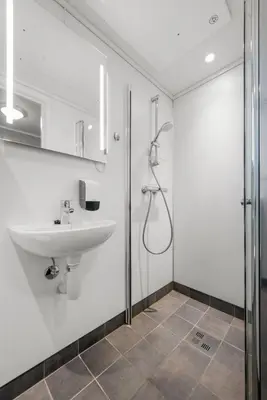 a bathroom with a sink and a shower at Norpark Romutleie in Orkanger