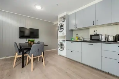 a kitchen and dining room with a table and appliances at Norpark Romutleie in Orkanger