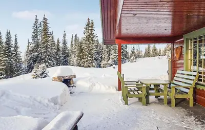 a cabin with a table and chairs in the snow at Cozy Home In Ulnes With Sauna in Ulnes