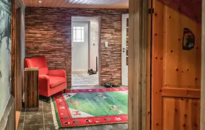 a living room with a red chair and a rug at Cozy Home In Ulnes With Sauna in Ulnes