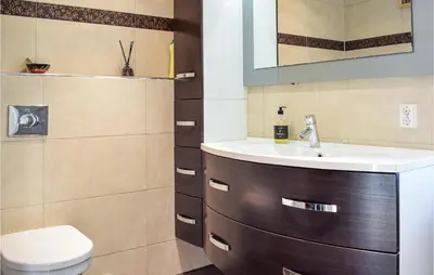 a bathroom with a sink and a toilet at 4 Bedroom Cozy Home In Fitjar in Fitjar