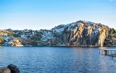 a lake with a dock in front of a mountain at 4 Bedroom Cozy Home In Fitjar in Fitjar