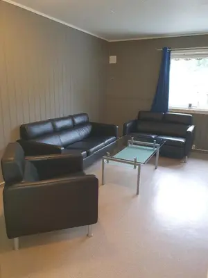 a living room with black leather furniture and a table at Leirvik i Sogn-Apartment in Leirvik