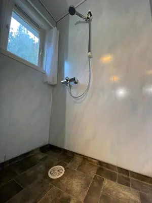 a shower stall in a bathroom with a window at Leirvik i Sogn-Apartment in Leirvik