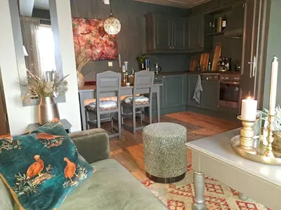 a living room with a couch and a kitchen with a table at 2 leiligheter med nydelig utsikt og hotell-følelse in Beitostøl