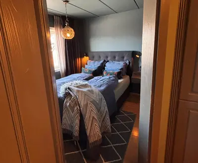 a bedroom with a bed with blue sheets and blue pillows at 2 leiligheter med nydelig utsikt og hotell-følelse in Beitostøl