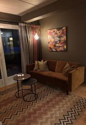 a living room with a couch and a table at 2 leiligheter med nydelig utsikt og hotell-følelse in Beitostøl