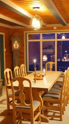 a dining room with a table and chairs and a clock at Moonvalley Lodge - stort & koselig hus - Måndalen in Sæbø