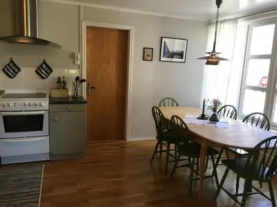 a kitchen and dining room with a table and chairs at Moonvalley Lodge - stort & koselig hus - Måndalen in Sæbø