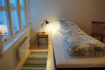a bed in a room with a lamp and a window at Moonvalley Lodge - stort & koselig hus - Måndalen in Sæbø
