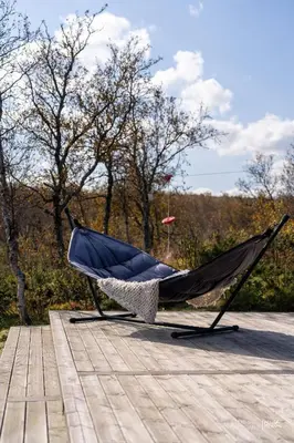 a hammock sitting on top of a wooden deck at Nydelig og Moderne hytte på Kikut Geilo - 6 senger, 4 soverom og jacuzzi in Geilo