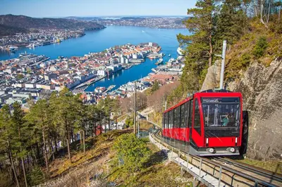a red tram on a hill overlooking a harbor at Brand new and luxurious penthouse in Bergen city centre! in Bergen