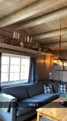a living room with a blue couch and a table at Koselig familiehytte på vakre Dagali - nær Geilo in Dagali