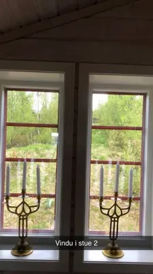 two candles on a shelf in front of two windows at Koselig familiehytte på vakre Dagali - nær Geilo in Dagali