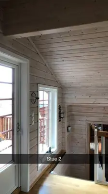 a room with wooden walls and a door and a window at Koselig familiehytte på vakre Dagali - nær Geilo in Dagali