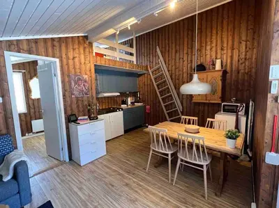 a kitchen and dining room with a table and chairs at Koselig hytte med uteplas ved Hallingdalselva in Ål