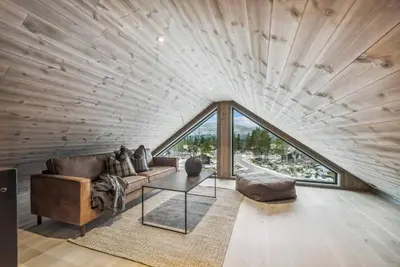 a living room with a couch and a large window at Brand new cabin at Hovden cross-country skiing in Hovden
