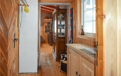 a kitchen with wooden walls and a long hallway at Awesome Home In Ustaoset With Wifi in Ustaoset