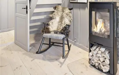 a chair in a living room next to a fireplace at 4 Bedroom Nice Home In Rauland in Rauland