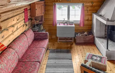 a living room with a couch in a log cabin at Cozy Home In Vinstra With Kitchen in Vinstra