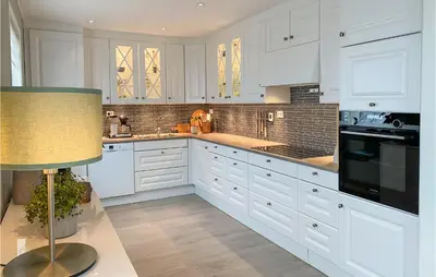 a white kitchen with white cabinets and a lamp at Awesome Home In Olden With Wifi in Olden