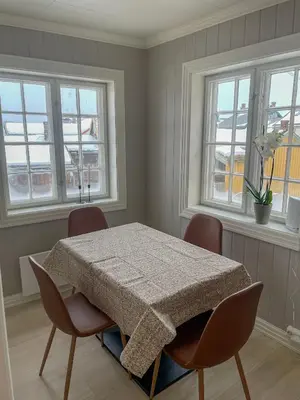 a dining room with a table and chairs and windows at Villa Gulstua in Røros