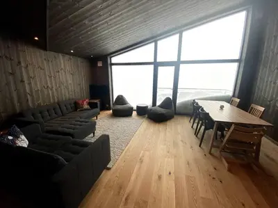 a room with a table and chairs and a large window at Cosy apartment with ski in/out in Noresund