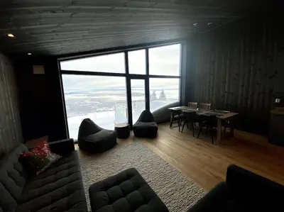a living room with a table and a large window at Cosy apartment with ski in/out in Noresund