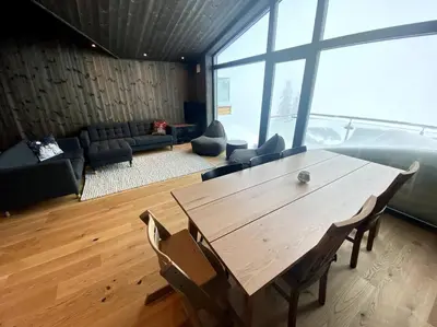 a large living room with a wooden table and chairs at Cosy apartment with ski in/out in Noresund