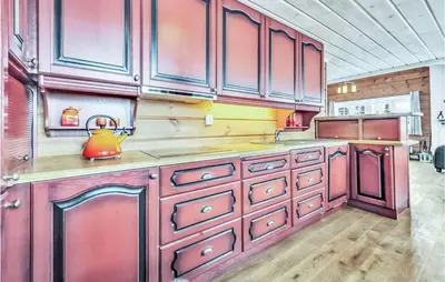 a kitchen with red cabinets and a tea kettle on the counter at Beautiful Home In Rjukan With Sauna in Rjukan