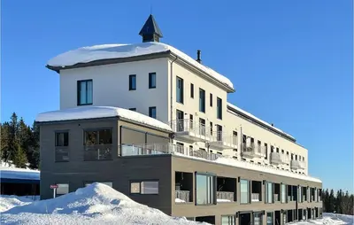 a building with snow on the ground in front of it at Cozy Apartment In Lillehammer With Wifi in Lillehammer