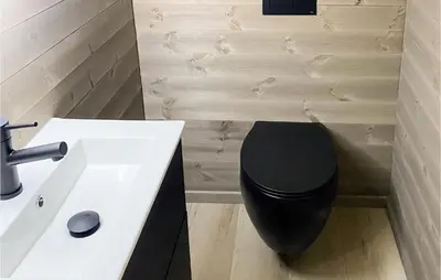 a bathroom with a black toilet and a sink at Nice Home In Edland With Wifi
