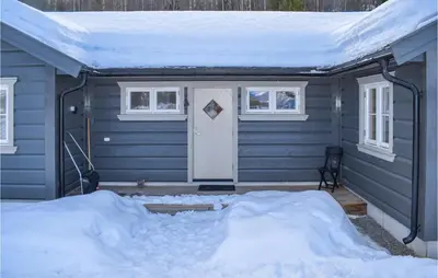 a blue house with a snow covered roof at Gorgeous Home In Noresund With Wifi in Noresund