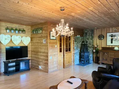 a living room with a chandelier and a fireplace at Flåm Holiday Home in Flåm