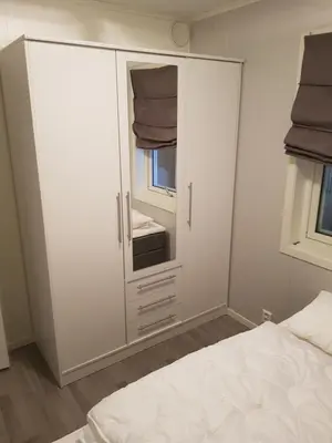 a bedroom with a white cabinet with a mirror at Fjærland Våteviksvegen 17 in Bøyum
