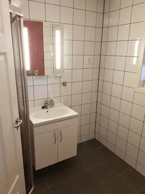 a white bathroom with a sink and a mirror at Fjærland Våteviksvegen 17 in Bøyum