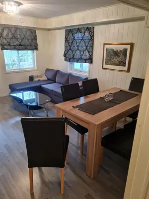 a living room with a table and a blue couch at Fjærland Våteviksvegen 17 in Bøyum