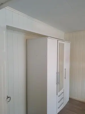 a white closet with a mirror and a door at Fjærland Våteviksvegen 17 in Bøyum