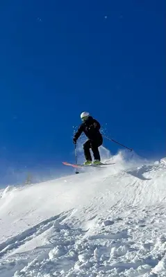 a person is skiing down a snow covered slope at Molden 2-fjellutsikt og jacuzzi tilgang. in Luster