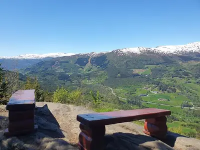 a wooden bench sitting on top of a mountain at Molden 2-fjellutsikt og jacuzzi tilgang. in Luster
