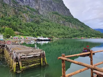 a boat is docked at a dock on a lake at Molden 2-fjellutsikt og jacuzzi tilgang. in Luster