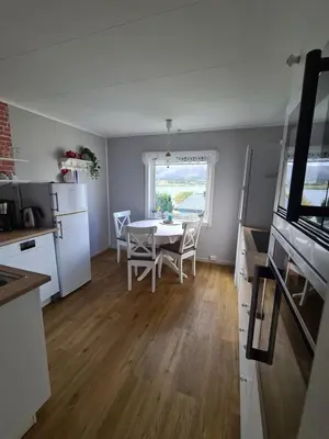 a kitchen and dining room with a table and chairs at Holiday Apartment in Flatanger in Vik