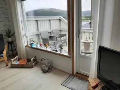 a room with a window with a view of a house at Holiday Apartment in Flatanger in Vik
