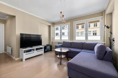 a living room with a blue couch and a tv at 2 min to Bryggen - Rooftop - Office with 49