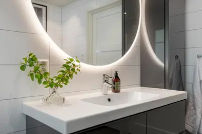 a white bathroom with a sink and a mirror at Grand and modern cabin in Sogndal