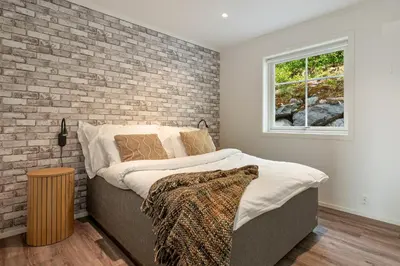 a bed in a room with a brick wall at Grand and modern cabin in Sogndal
