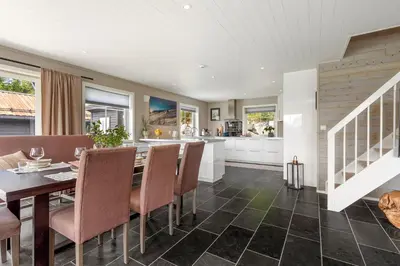 a kitchen and dining room with a table and chairs at Grand and modern cabin in Sogndal