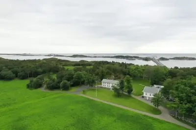 an aerial view of a house with a green field at Storlauvøya The Atlantic Ocean Road in Karvåg